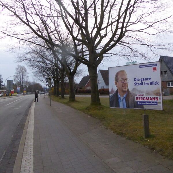Das Bild zeigt eine Großflächen für die Oberbürgermeisterwahl in Neumünster - für den Kandidaten der SPD Tobias Bergmann (Querformat) und den Kandidaten der CDU Olaf Tauras
