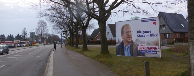Das Bild zeigt eine Großflächen für die Oberbürgermeisterwahl in Neumünster - für den Kandidaten der SPD Tobias Bergmann (Querformat) und den Kandidaten der CDU Olaf Tauras