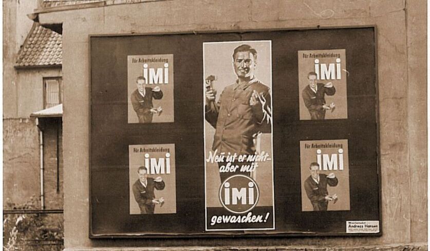 Ein Sepia-Bild, das ein Plakat zeigt, auf dem eine nostalgische Werbung für imi Waschmittel abgebildet ist.